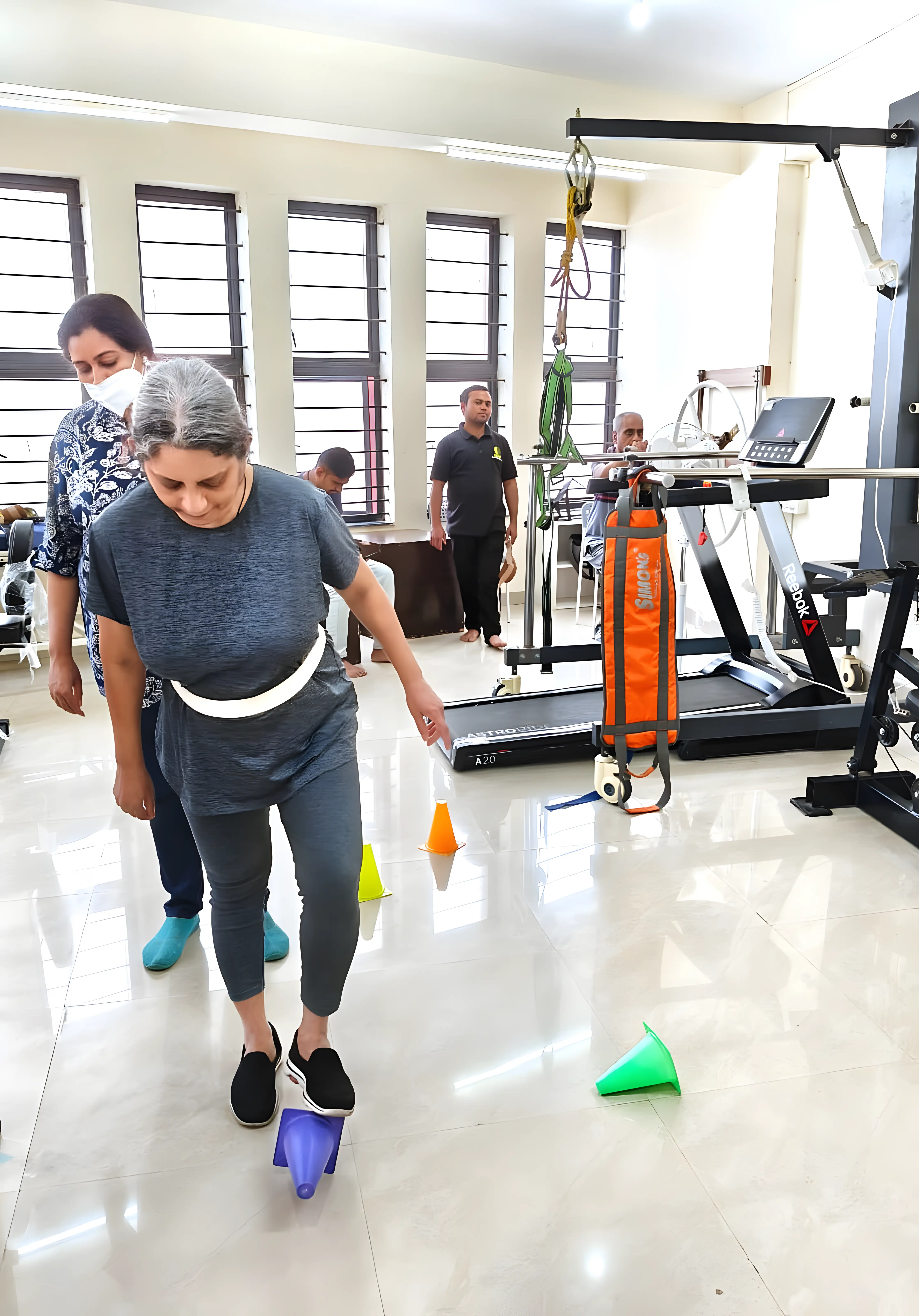 Physiotherapist assisting a Multiple Sclerosis patient with gait training exercises at Regen Neuro Rehabilitation Physiotherapy Centre