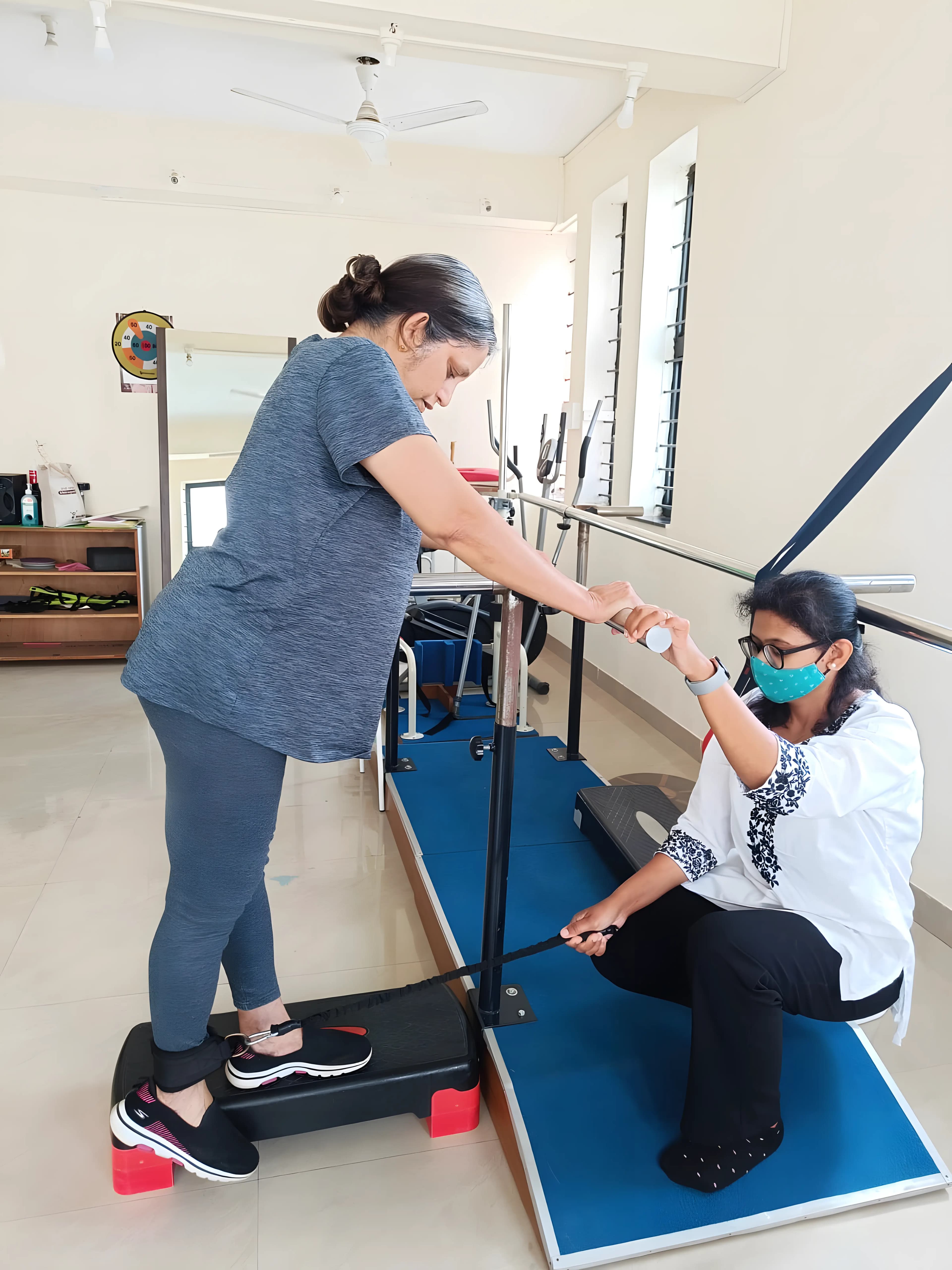 Physiotherapist assisting a patient with stepping exercise for gait and balance training at Regen Neuro Rehabilitation Physiotherapy Centre