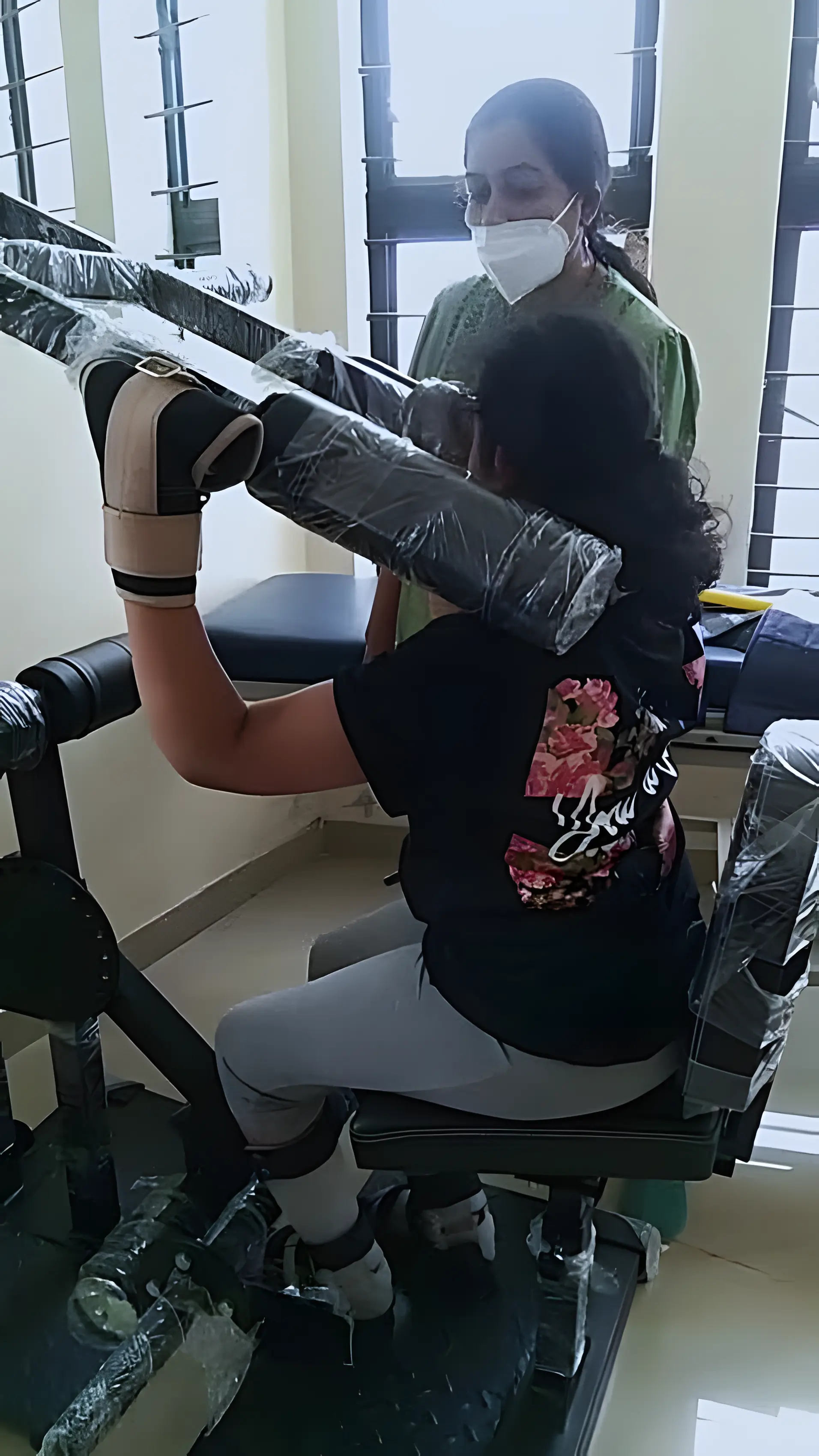 Physiotherapist assisting a patient with resisted sit-to-stand exercise using shoulder press at Regen Neuro Rehabilitation Physiotherapy Centre